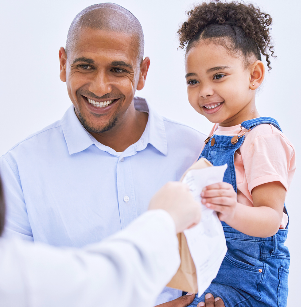 Man holding a little girl seeing a doctor in a white coat